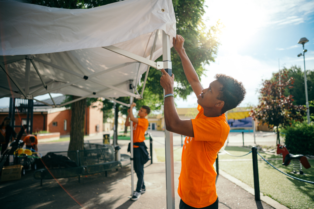 En ungdom i Juniorlaget sätter upp ett tält.