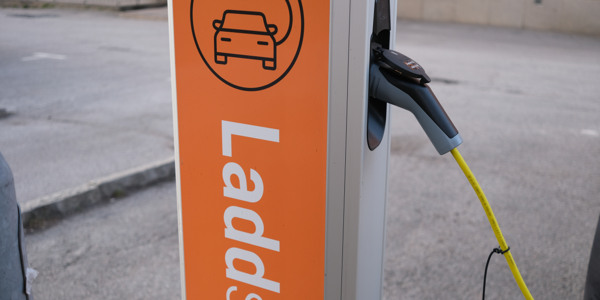 En laddstolpe med en skylt som anger att den driftas av Hyresbostäder.