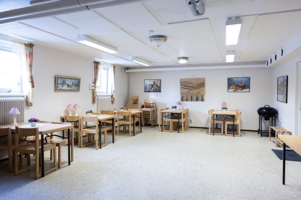 Kvarterslokal Västra Lund: Allrum med träbord och trästolar.