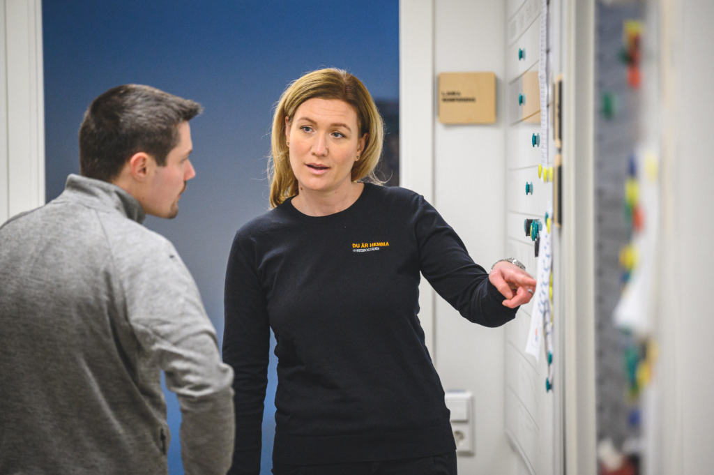 Två anställda står framför en whiteboard och diskuterar. 