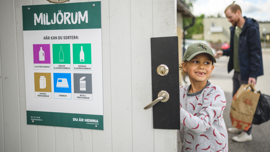 Ett barn som går in i ett miljörum för att källsortera