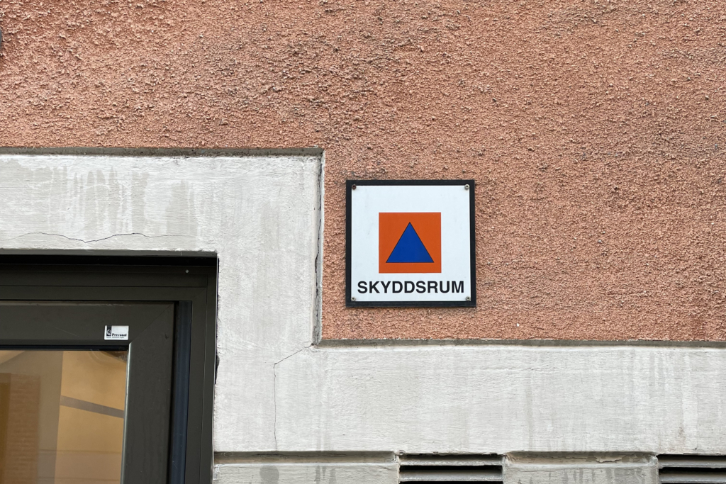 En fasad på lägenhetshus med skylten "skyddsrum".