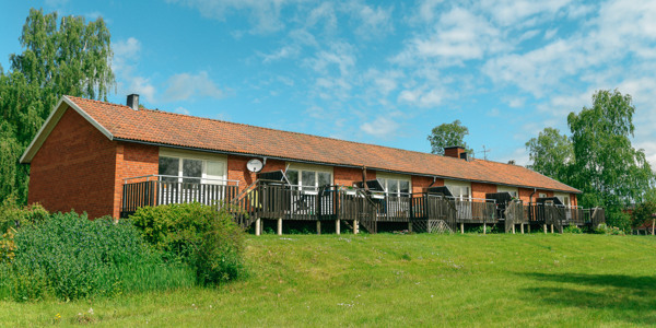 Seniorboende Björkängen, Kuddby: rött tegelhus som ligger på ett grönskande fält