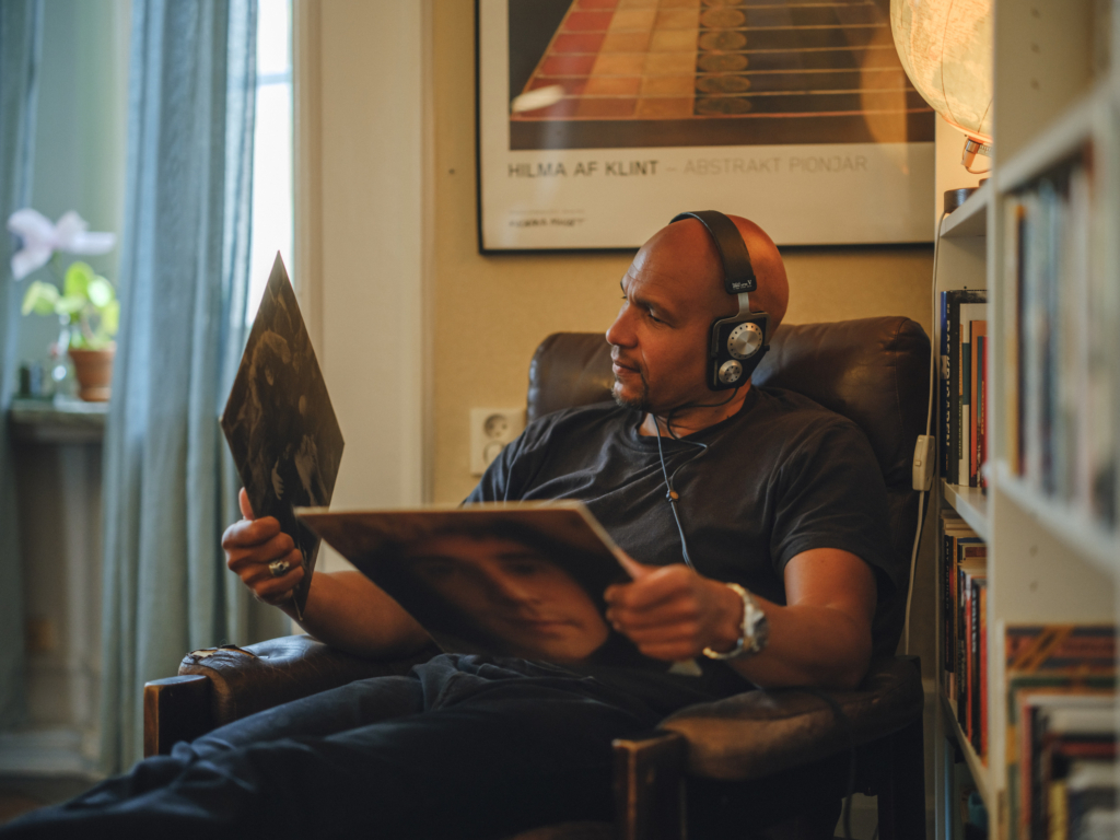 En hyresgäst som sitter i en fåtölj och lyssnar på musik.