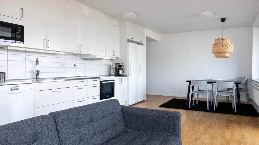 Bo tillsammans-lägenhet: Ett vardagsrum med möbler och ett kök.