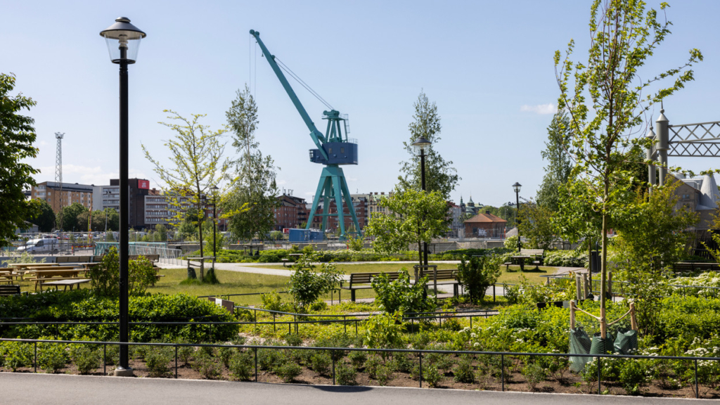 Varvsparken i Inre hamnen, grönt område med parkbänkar. I bakgrunden syns den klassiska blåa kranen.