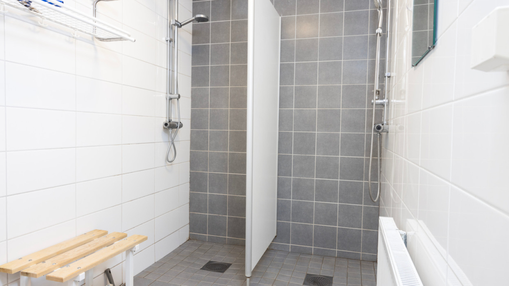 Gemensam dusch på Assessorn, plan 2. I rummet finns två duschar som separeras med en vägg.