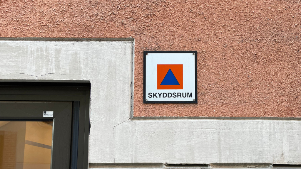 En fasad på lägenhetshus med skylten "skyddsrum".