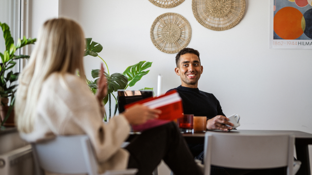 Två studenter sitter vid ett bord och studerar och dricker kaffe.